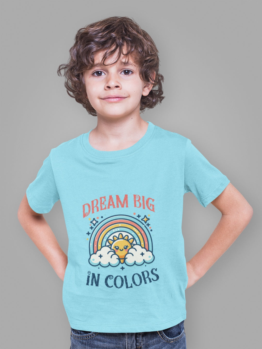 Unique boys t-shirt with rainbow design worn by a smiling boy in a light blue tee with Dream Big in Colors print