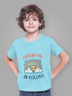 Unique boys t-shirt with rainbow design worn by a smiling boy in a light blue tee with Dream Big in Colors print